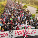 Miles de personas de diferentes nacionalidades rezaron antes de avanzar en una nueva caravana migrante con la ilusión de llegar a los Estados Unido. Al frente unos cargaban una cruz de Madera, con una manta que decía: “el éxodo de la pobreza" © Damián Sánchez/cuartoscuro.com