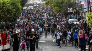 Migrantes llevan una cruz al frente de una caravana que pretende llegar a la frontera entre México y Estados Unidos, saliendo desde Tapachula, estado de Chiapas, el 25 de marzo de 2024 © Isaac Guzmán/AFP via Getty Images