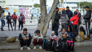 Migrantes deportados descansan en un andén en el puerto fronterizo de El Chaparral, en Tijuana, México, el 22 de enero de 2025 © EFE/ Joebeth Terríquez