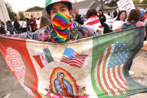 Un manifestante sostiene una bandera de EE. UU. y México durante una protesta en Ontario contra las deportaciones masivas © Genaro Molina, Los Angeles Times